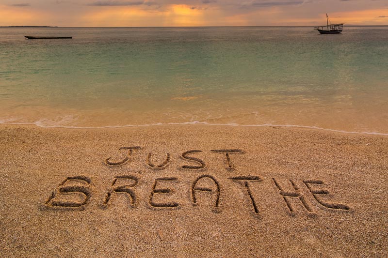 Just Breathe written in the Sand